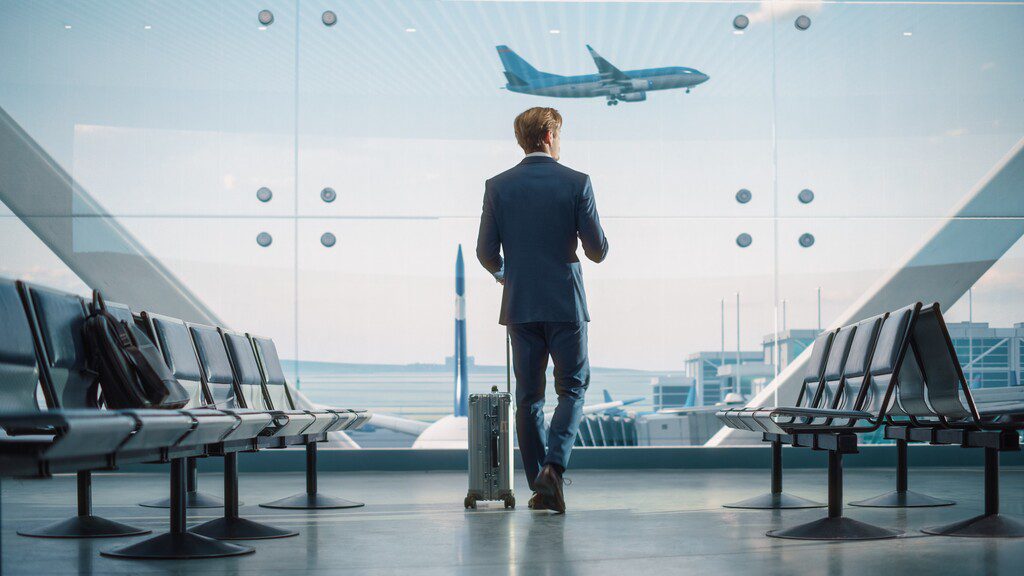 homem em aeroporto se preparando para viagem, representando o tema adicional de deslocamento